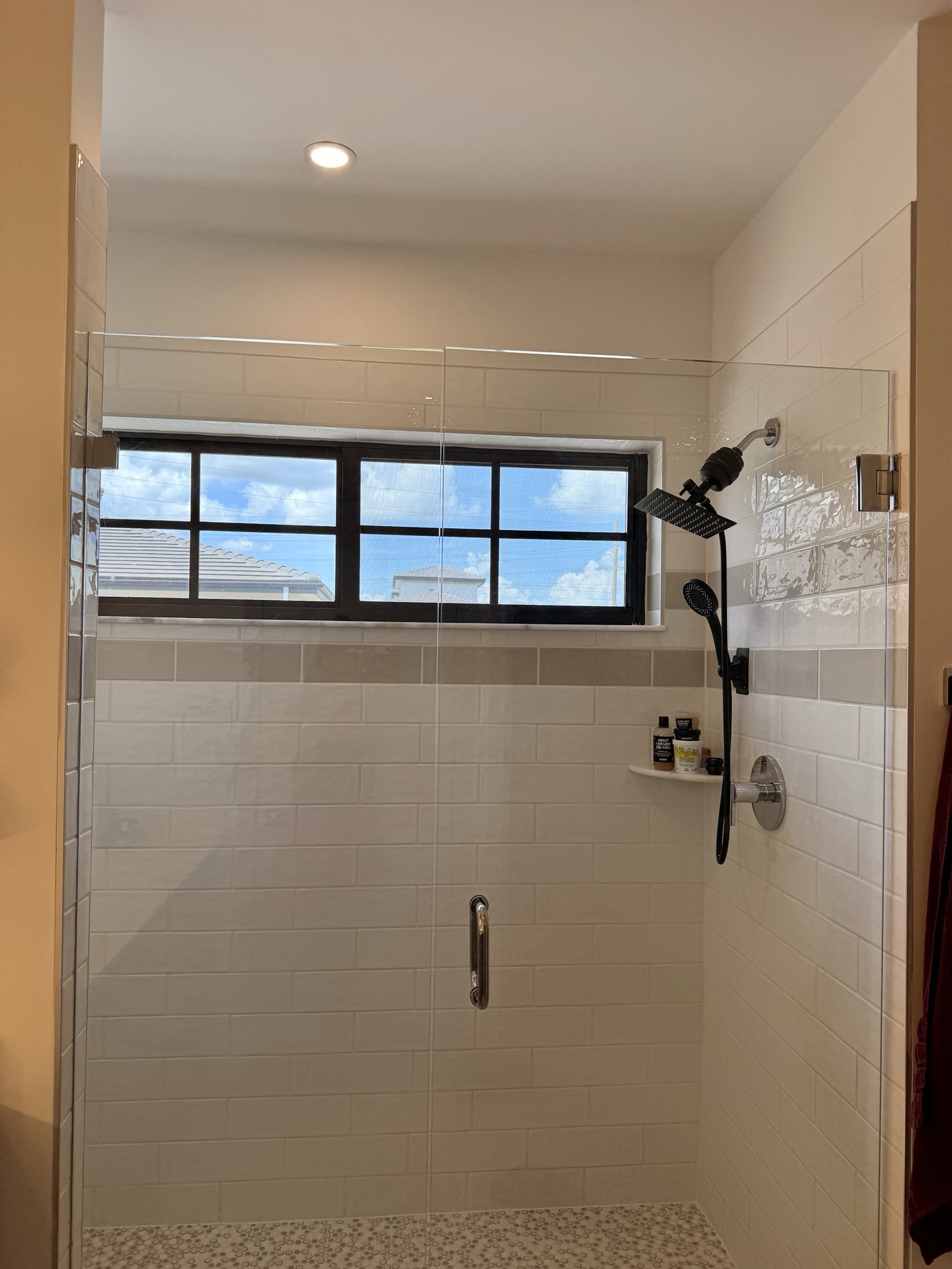 Walk-in shower with subway tile and a window