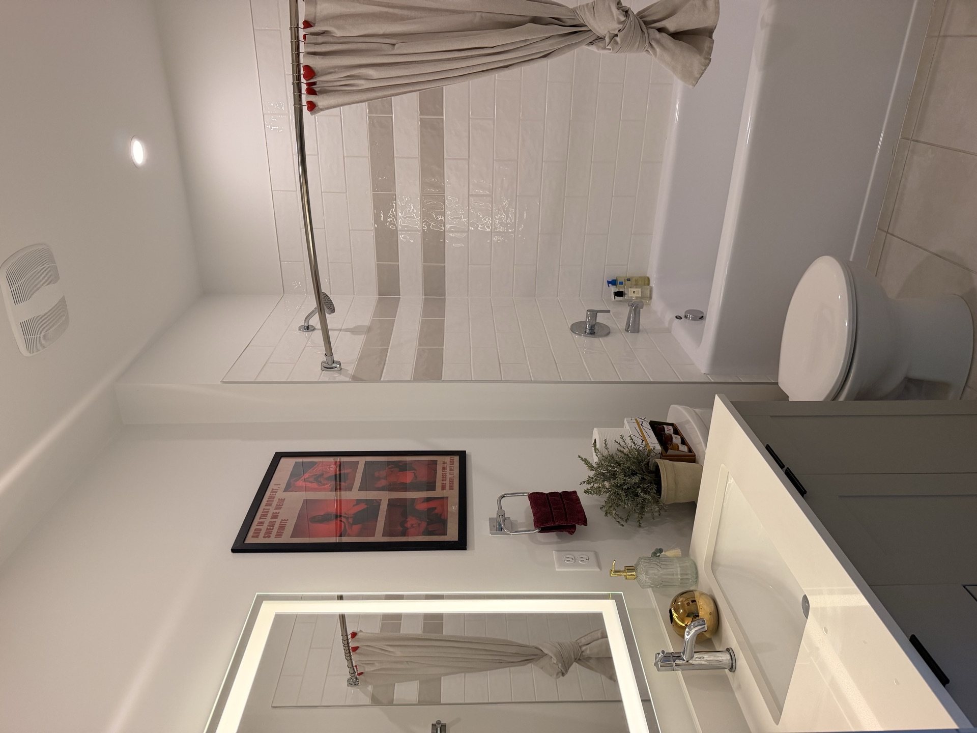 Bathroom with tub, heart curtain rings, and red towels
