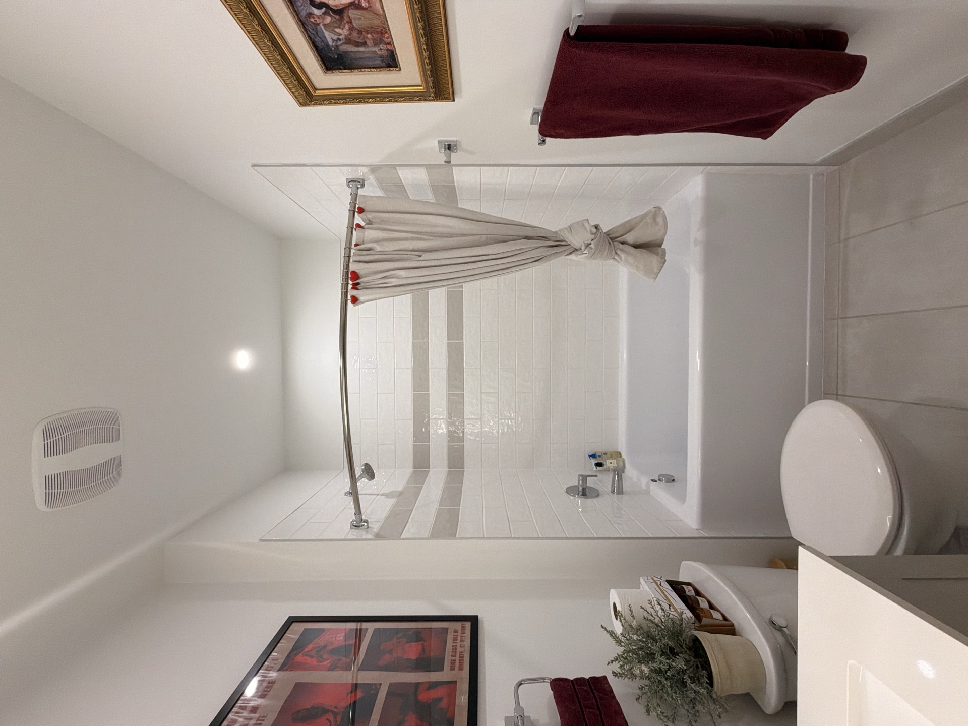 Bathroom with tub, toilet, and maroon accents